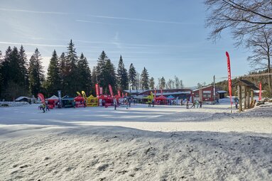 Aufgebaute Pavillons von Marken in der Langlaufbranche und davor langläufer | © Woidlife 