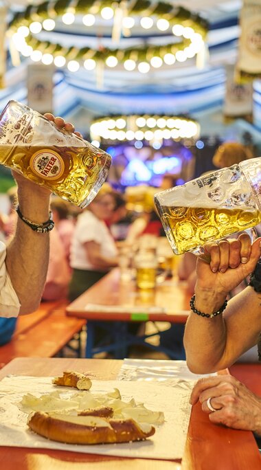 Mann und Frau in Tracht trinken Bier aus ihren Maßkrügen im Bennofest Festzelt. | © Bodenmais Tourismus & Marketing GmbH