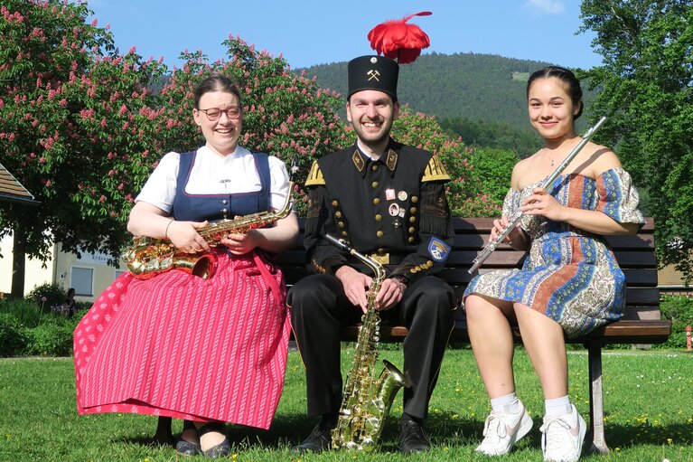 Drei Musikanten sitzen auf einer Bank mit ihren Instrumenten | © Bodenmais Tourismus & Marketing GmbH