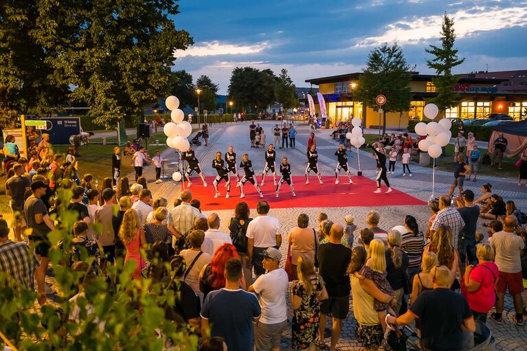 Auf einem mit rotem Teppich ausgelegten Platz tritt eine Tanzgruppe auf. Davor versammeln sich Zuschauer. | © Bodenmais Tourismus & Marketing GmbH